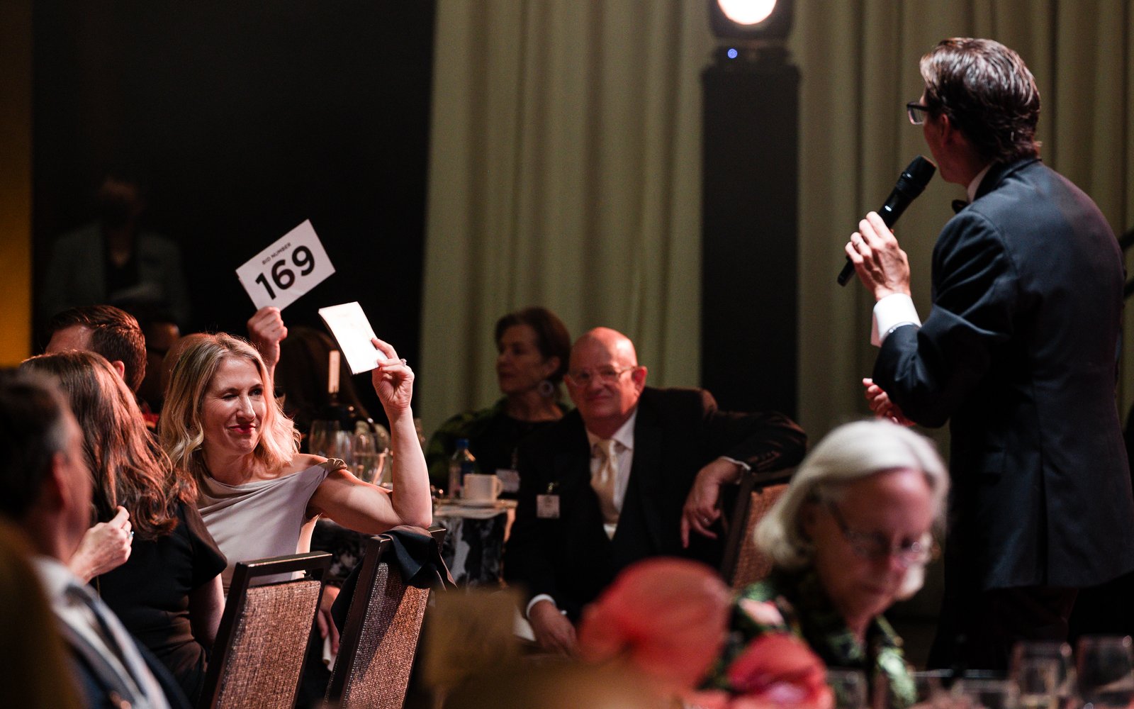 A guest bids on an item during the live auction (Dammel Photographic Works)