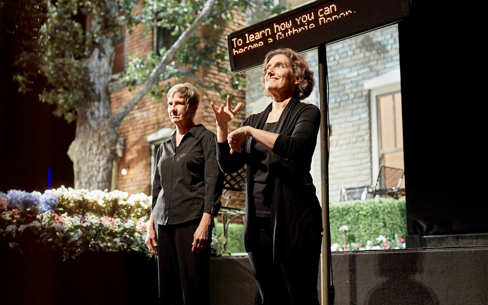 Two women ASL interpret the speaking portion of an event at the Guthrie