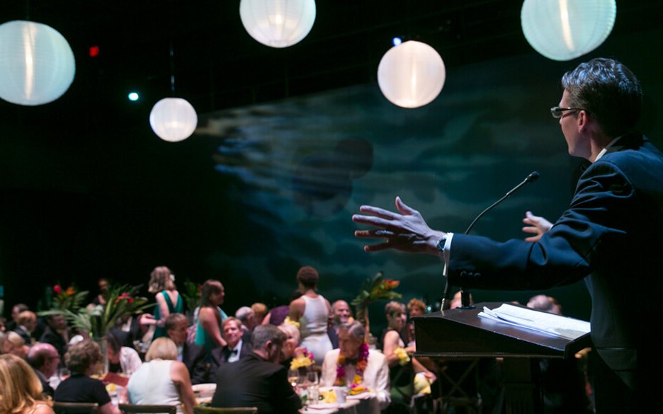 A keynote speaker delivers a speech at a podium in the Dowling Studio