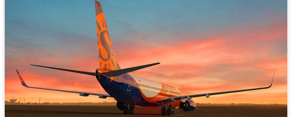 An image of a Sun Country jet on a tarmac at sunset